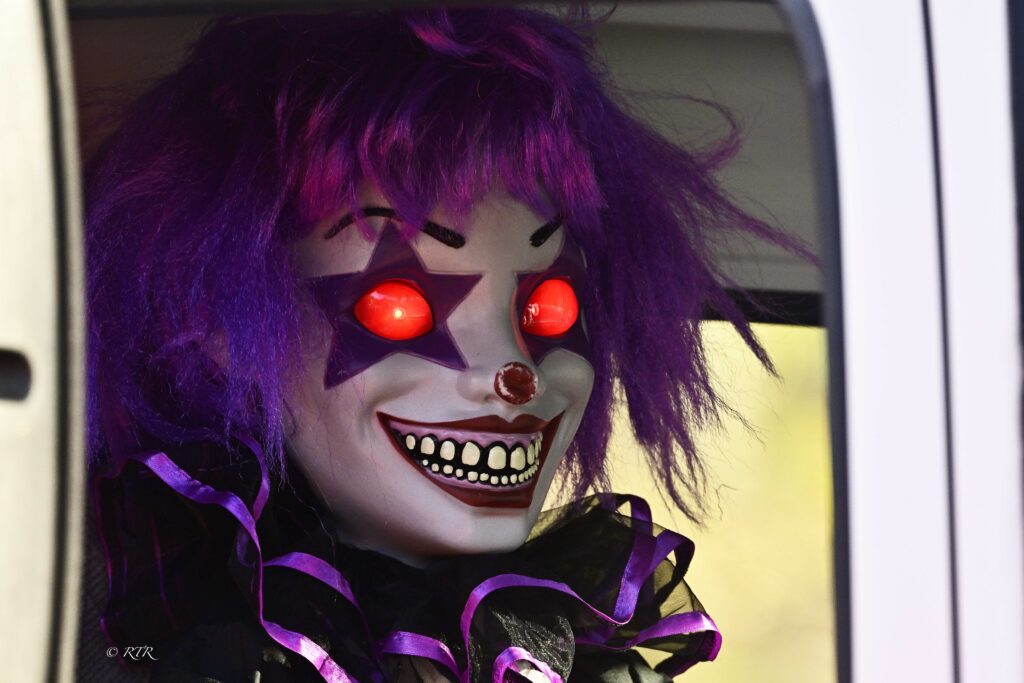 A purple-haired clown decoration with red eyes.