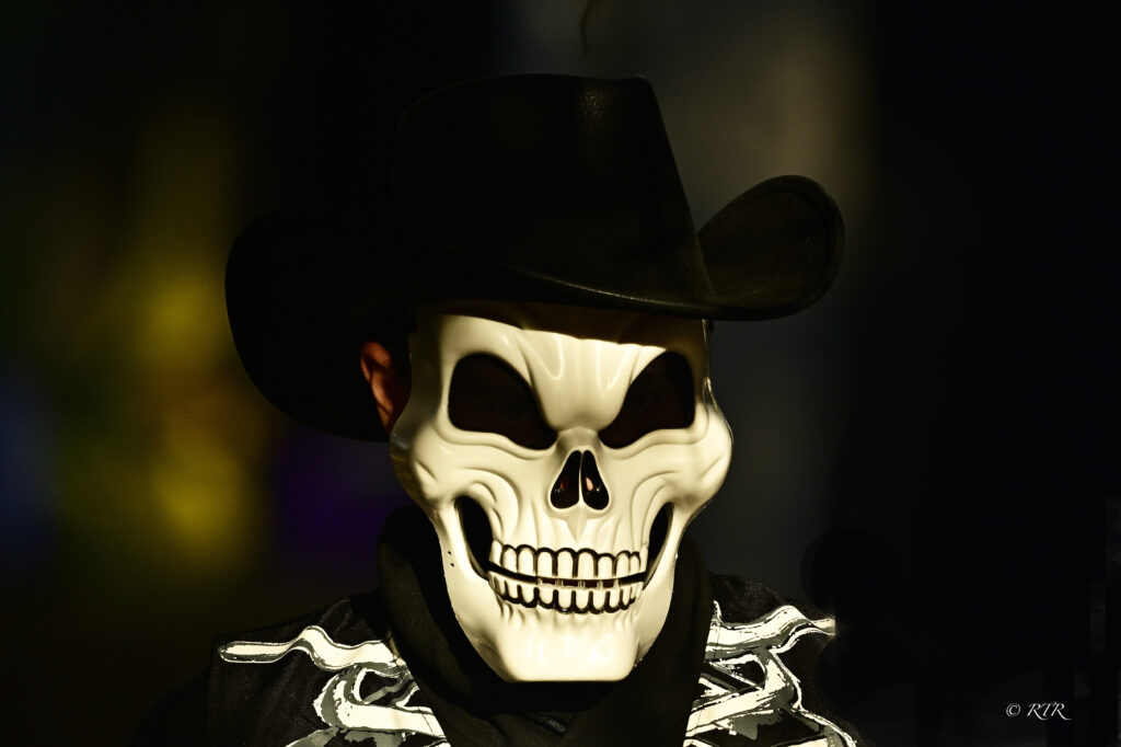 A skeleton mask and black cowboy hat in Ronny Rooster’s Halloween photograph.