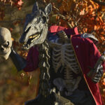 A headless horseman decoration holds a skull beside a skeletal horse.