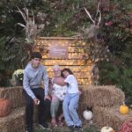From left, Julio, Pattie Urry and Ellyiah pose together in an autumn display.
