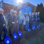 Participants hold blue shovels at the Petrolia hospital redevelopment groundbreaking.