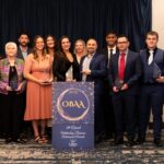 Winners at the 2026 Outstanding Business Achievement Awards pose together with their trophies.
